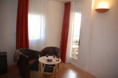 kleine Sitzecke vor dem möblierten Balkon