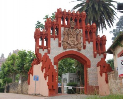 DSC_1187Puerta de la antigua Universidad Pontificia de Comillas.JPG (78 KiB) 8396 mal betrachtet Das Tor der alten Universität von Comillas<br /><br />errichtet im Neugotischen-, Mudéjar- und Jugendstil, stammt aus dem Jahr 1889 und ist der Eingang zum Anwesen von Cardosa, in dem sich das Seminar befindet. Es ist eine harmonische Mischung aus Ziegeln, glasierter Keramik mit metallischem Glanz und behauenen Steinen.<br />Auf dem von zwei Kindern in aufwändiger Kleidung getragenen Wappen, über dem sich eine Krone befindet, sieht man die päpstliche Tiara und den Papstschlüssel zusammen mit den Jesuiten-Monogramm IHS (Iesum Habemus Socium - „Wir haben Jesus als Gefährten“). Die Figuren der Kinder werden von zwei Neidköpfe (quimeras) mit orientalischem Einfluss getragen.
